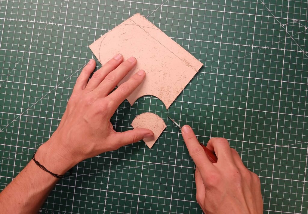 Découpe manuelle d'une courbe dans une pièce de cuir à l'aide d'un couteau de maroquinier